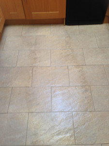 Poreclain floor tile showing dirty tiles left and right of the first clean through
